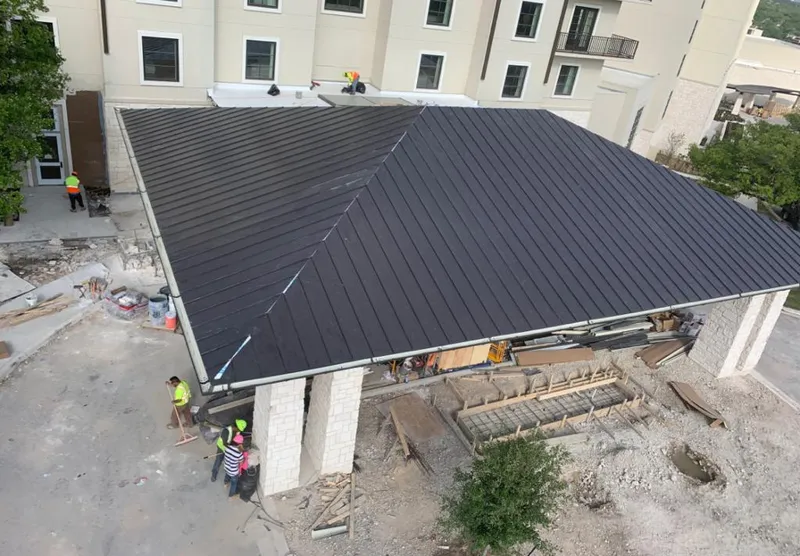 Metal roofing installation team working on a commercial building in Van Buren